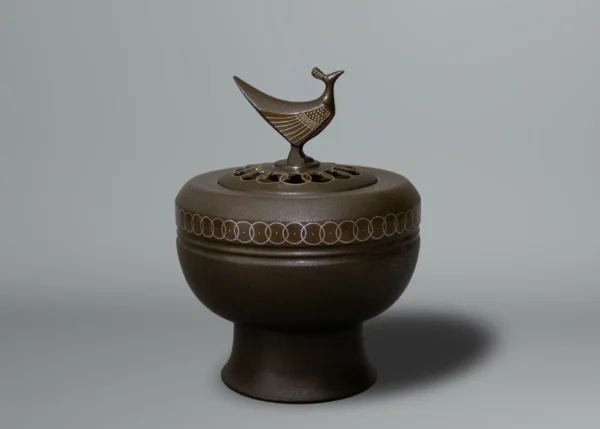 Brûle encens en bronze patiné, décoré de cercles entrelacés, le couvercle percé surmonté d’un oiseau stylisé par Takahashi Kaishu